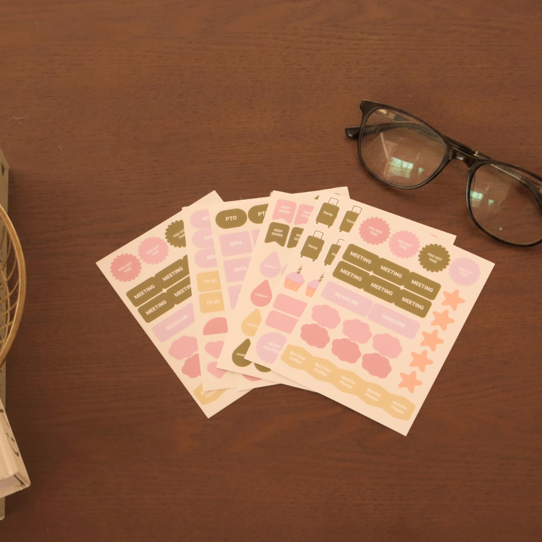 Set of planner stickers on a wooden surface with glasses in the background